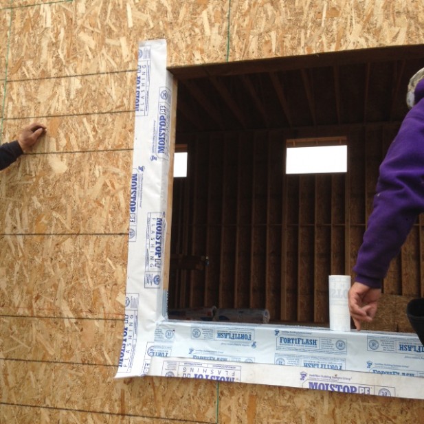 Sequence of proper window installation using self adhered membrane flashing, caulking and weather resistant barrier, new construction home